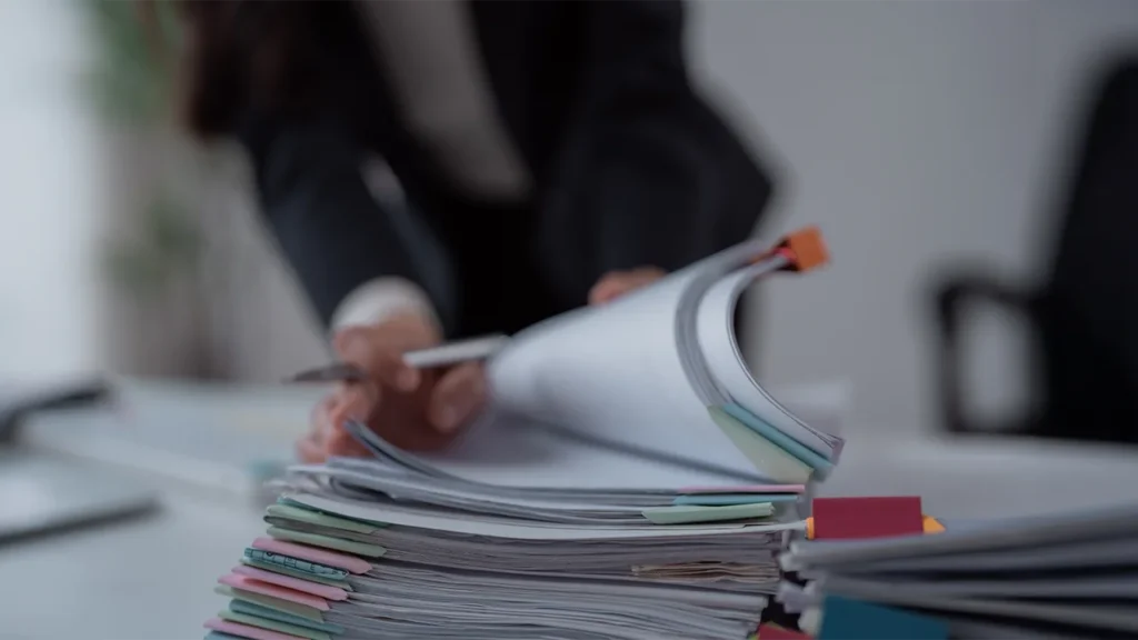 attorney flipping through mountain of paperwork